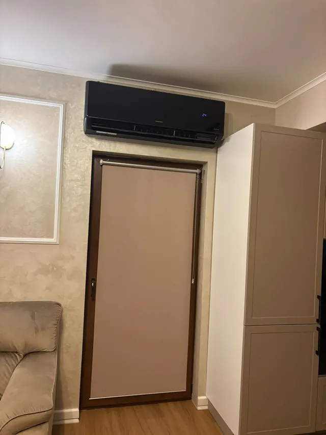 Aparat negru montat deasupra ușii, în living